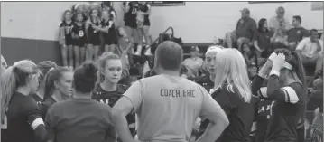  ?? STAFF PHOTO BY JOHN NISWANDER ?? The La Plata Warriors volleyball team, under head coach Ashley Buchanan, second from right, talk during a timeout in Thursday night’s match at Leonardtow­n. The Warriors lost the opening set, then battled back to win in four.