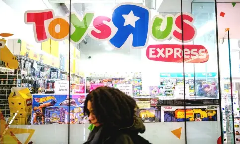  ??  ?? A pedestrian passes in front of a Toys R US store in New York on Mar 15. — WP-Bloomberg photo
