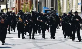  ?? PHOTOS BY TIMOTHY D. EASLEY — THE ASSOCIATED PRESS ?? Armed members of the NFAC march through downtown Louisville, Ky., toward the Hall of Justice on Saturday. They were demanding justice for Breonna Taylor.