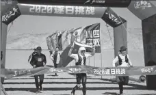  ?? PHOTOS PROVIDED TO CHINA DAILY ?? Top: Pan Junfan runs in the Ironman Western Australia in 2019. Above: Pan (center) crosses the finish line in Guazhou, Gansu province, on Sept 18, flanked by members of his support team.