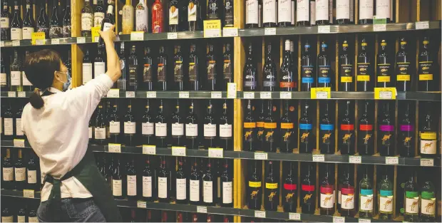  ?? NOEL CELIS / AFP VIA GETTY IMAGES ?? Australian-made wine, on display shelves at right, may be one of the products in play if the Conservati­ve proposal for more free trade with the
country comes to fruition, but analysts say free movement in labour mobility would be a bigger prize.