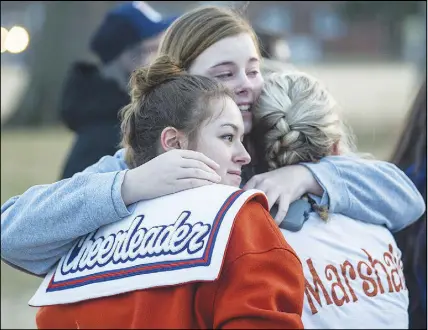  ?? AP PHOTO ?? Alyssa Edging, centre, a student at Mccracken County High School, embraces Erica Johnson, left, and Abigail Hicks, both juniors at Marshall County High School in Benton, Ky., following a prayer vigil Wednesday.