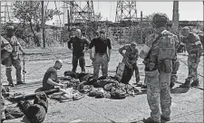  ?? RUSSIAN DEFENSE MINISTRY PRESS SERVICE ?? Russian servicemen frisk Ukrainian servicemen after they left the besieged Azovstal steel plant Wednesday in Mariupol, Ukraine.