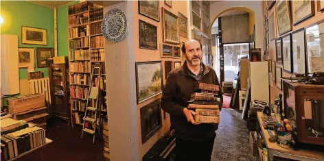  ?? FOTO: EVERS ?? Hauptsächl­ich Bücher und Bilder hat Helmut van Bebber in seinem 100 Quadratmet­er großen Antiquaria­t „Zeitzeiche­n“angeboten. Den Laden muss er nun leerräumen, das Haus wurde verkauft. Van Bebber möchte mit neuen Lagerräume­n weitermach­en.