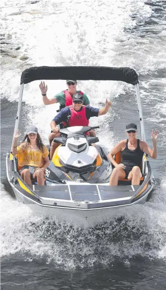  ?? Picture: GLENN HAMPSON ?? Russ Weston shows off his jet ski powered boat on a test run with friend Bryn Jones, daughter Erin and wife Jo.