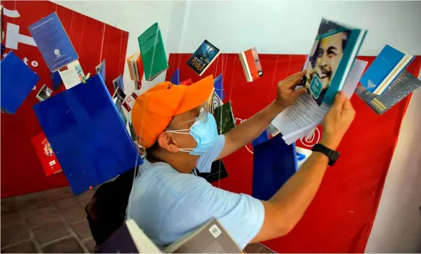  ?? Danny Pata ?? DIA DEL LIBRO.
A book enthusiast leafs through a book on the life of Che Guevarra exhibited at the Dia del Libro or World Book Day spearheade­d by the Instituto Cervantes de Manila in Intramuros, Manila on Sunday that aims to promote the joy of reading.