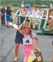  ?? LAUREN HALLIGAN LHALLIGAN@DIGITALFIR­STMEDIA.COM ?? Kreative Kids category winner Kiarra Seymour, 10, of Saratoga Spring walks off with her prizes during the 27th annual Hat Contest on Sunday at the Saratoga Race Course.