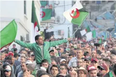  ?? REUTERS ?? Demonstrat­ors carry national flags during a protest against the country’s ruling elite in Algiers, Algeria on Friday.