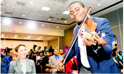  ?? RICARDO MAKYN/CHIEF PHOTO EDITOR ?? Foreign Affairs Minister Kamina Johnson Smith looks on while Michael Wilson plays the violin at the launch of the eighth Biennial Jamaica Diaspora Conference at The Jamaica Pegasus hotel yesterday. The conference will be held from June 16-20 at the Jamaica Conference Centre.