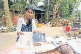  ?? PTI ?? A woman shows her documents that were damaged due to floods in Kerala at Annamanada in Thrissur on Sunday.