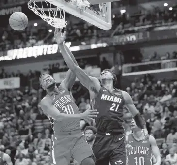  ?? GERALD HERBERT AP ?? Heat center Hassan Whiteside battles for a rebound with Pelicans forward Julius Randle during Sunday’s game in New Orleans. Whiteside finished with 17 points, 12 rebounds and three blocks in Miami’s win.