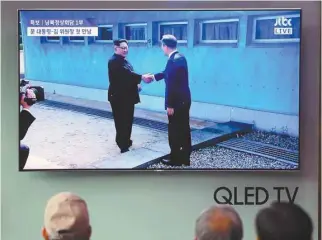 ?? JUNG YEON-JE AGENCE FRANCE-PRESSE ?? Les dirigeants des deux Corées ont échangé une poignée de main sur la ligne de démarcatio­n, vendredi.