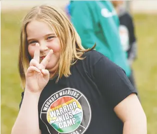  ?? IAN KUCERAK ?? Mackenna Thompson flashes the peace sign at the Wounded Warriors Canada Warrior Kids Camp at Camp Van-es near Sherwood Park Sunday.