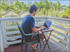  ?? Marley C. Alford photo via AP ?? Raymond Berger, a New York City software engineer, is pictured working remotely last week in Kahului. A group of state leaders is trying to attract people like Berger to work remotely from Hawaii during the pandemic.