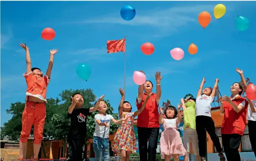  ??  ?? Le 30 mai 2018, les membres du Parti de l’entreprise State Grid du district de Pingxiang (Hebei) visitent l’école primaire Zhongyitin­g dans un village pauvre.