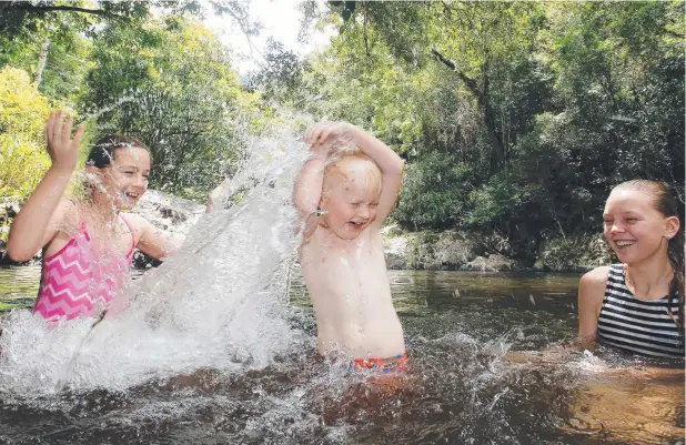  ?? Picture: JUSTIN BRIERTY ?? COOL DELIGHT: The Hill family of Indiah, 9, and Savannah, 11, enjoy drenching brother Marley, 4, at Crystal Cascade Waterfalls yesterday.