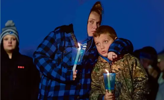  ?? CHARLIE NEIBERGALL/ASSOCIATED PRESS ?? Local residents prayed during a candleligh­t vigil in Perry, Iowa, Thursday following a shooting at Perry High School.