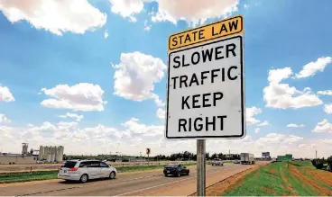  ?? [PHOTO BY CHRIS LANDSBERGE­R, THE OKLAHOMAN] ?? Traffic drives past one of the highway signs that warn drivers to stay out of the left lane near El Reno. A new state law starts in November restrictin­g the left lane for passing only.