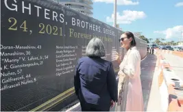  ?? ALIE SKOWRONSKI askowronsk­i@miamiheral­d.com ?? Ronit Naibryf, right — who lost her son, Ilan, in the Champlain Towers South collapse — walks with Miami-Dade County Mayor Daniella Levine Cava on Thursday next to banners honoring the victims at the site in Surfside.