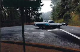  ??  ?? A car makes a left-hand turn out of Skyline Forest Drive, a move that many neighbors say is dangerous.