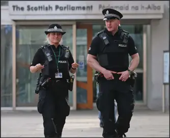  ??  ?? Police are seen on patrol outside the Scottish Parliament in Edinburgh