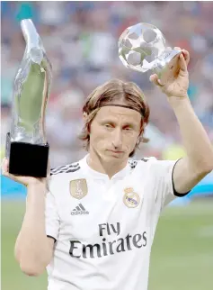  ??  ?? File photo shows Real Madrid’s Luka Modric with the UEFA Men’s Player and Midfielder of the Year awards before the match. — Reuters photo