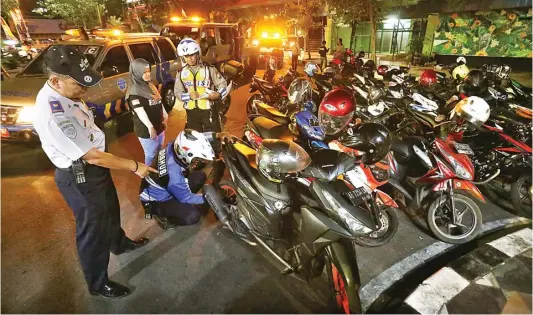  ?? AHMAD KHUSAINI/JAWA POS ?? TINDAKAN TEGAS:
Petugas dishub dan satlantas polrestabe­s menindak kendaraan bermotor yang parkir sembaranga­n. Tindakan berupa penilangan dan penggembos­an ban.