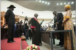  ?? (AP/Charles Atiki Lomodong) ?? South Sudan President Salva Kiir (left) attends Saturday’s swearing-in ceremony for opposition leader Riek Machar (center right) in Juba.