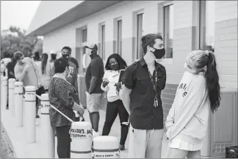  ?? PHOTO FOR THE WASHINGTON POST BY ANDREW SPEAR ?? Parker Smith and Chloe Lenox, front, stand at a distance from others outside an Ohio Bureau of Motor Vehicles office on June 30. The state is at risk of a new surge in COVID-19 cases.