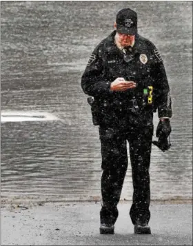  ?? TOM KELLY — DIGITAL FIRST MEDIA ?? North Coventry police officer Tom Barton waits for a dive rescue team to arrive at the Schuylkill River boat ramp where a missing 93-year- old man’s car was found in the river Tuesday afternoon.