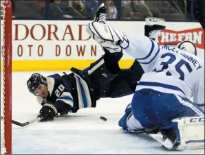  ?? AP PHOTO/PAUL VERNON ?? Columbus Blue Jackets forward Brandon Saad, left, is tripped in front of Toronto Maple Leafs goalie Curtis McElhinney during the second period of an NHL hockey game in Columbus, Ohio, Wednesday.