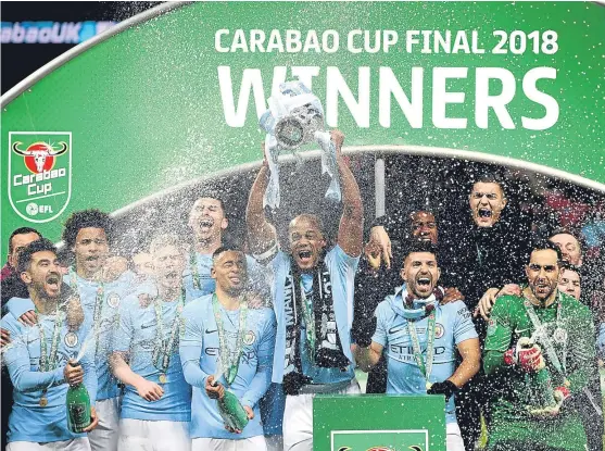  ?? Picture: PA ?? Manchester City captain Vincent Kompany holds the Carabao Cup aloft as his team-mates celebrate their victory.