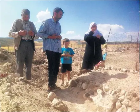  ?? Glen Johnson
For The Times ?? RELATIVES visit the graves of two Kurdish boys killed in August by Turkish security forces. Authoritie­s accuse Muhammet Aydemir, 15, and Orhan Arslan, 17, of being Kurdish guerrillas. Their families say the pair were innocents slain in cold blood.