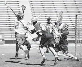  ?? KIM HAIRSTON/BALTIMORE SUN ?? Colin Heacock scores over Penn State goalie Colby Kneese in the second quarter. Heacock, a senior attackman from Boys’ Latin, had three goals and one assist.