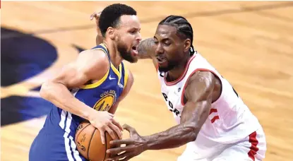  ?? (Frank Gunn/The Canadian Press via AP) ?? BATTLE OF THE GREATS.
Toronto Raptors forward Kawhi Leonard (2) defends against Golden State Warriors guard Stephen Curry (30) during firsthalf basketball action in Game 5 of the NBA Finals in Toronto, Monday, June 10, 2019.