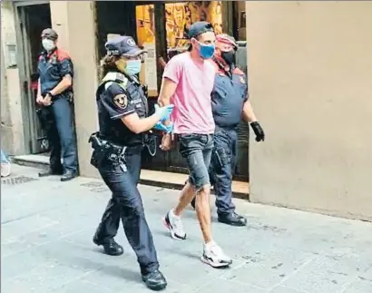  ?? LV ?? Una guardia urbana y un mosso trasladan a uno de los tres detenidos, la semana pasada en la calle Tallers