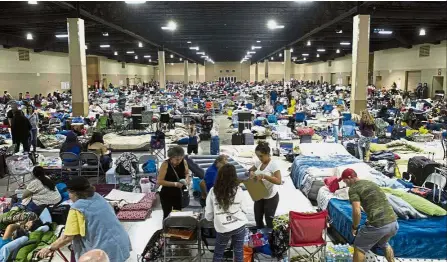  ??  ?? Batten down the hatches: Hundreds of people gathering (above) in an emergency shelter at the Miami-Dade County Fair Expo Centre in Miami ahead of Hurricane Irma and (below) a street in Miami Beach, Florida, left empty after many residents evacuated. —...