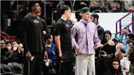  ?? Lynne Sladky/Associated Press ?? Miami Heat guard Tyler Herro, right, watches from the sideline during the second half of a game against the Charlotte Hornets on Wednesday in Miami.