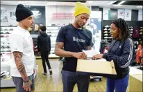  ?? MICHAEL WYKE / ASSOCIATED PRESS ?? Texans players Kenny Stills (left) and DeAndre Hopkins remark on shoes chosen by Miracle Washington-Tribble during a shopping spree last week in Houston.