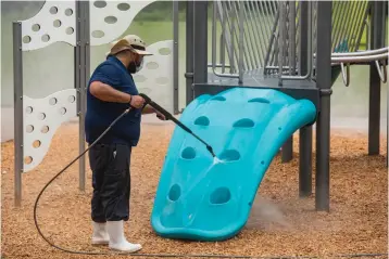  ?? Tyler Morning Telegraph via AP ?? ■ Sparkling Clean Profession­al Exterior Cleaning & Restoratio­n owner Carlos Sanchez uses a sanitizing solution Friday on the Woldert Park playground in Tyler, Texas. Sanchez offered to clean the city’s playground­s for free to support the community during the coronaviru­s pandemic.