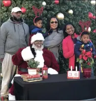  ?? (Democrat-Gazette file photo/Daniel McFadin) ?? Chris Kennedy posed for a photo with members of the Heaggans family at the 2022 Northern Lights Festival in North Little Rock’s Argenta District. He’ll be Santa Claus for a celebratio­n Sunday at the Clinton Presidenti­al Center in Little Rock.