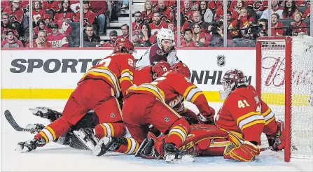  ?? GETTY IMAGES FILE PHOTO ?? J.T. Compher of the Colorado Avalanche takes a shot on goalie Mike Smith and several of his Flames teammates on Friday night.