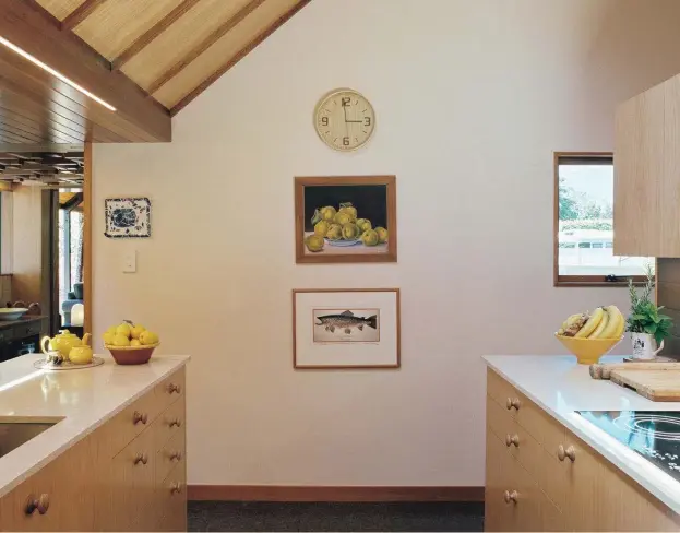  ??  ?? Above The painting of quinces is by Alice Harris and the trout is by Patricia Payne. Above, right The kitchen bench used to run along a wall and look onto the driveway. It has since been recast as an island to face the dining room. The light above the...