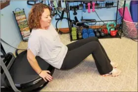  ??  ?? Shannon Anthony does a tradition tricep dip but on a vibration exercise machine. Anthony’s studio Serenity Fitness & Wellness in Boyertown allows members to get a faster workout by using the moving platforms.