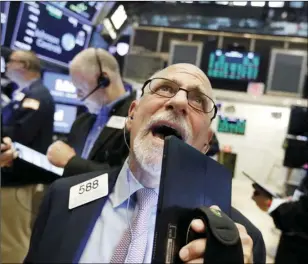  ??  ?? Trader Peter Tuchman works on the floor of the New York Stock Exchange, on Friday. AP PHOTO/RICHARD DREW