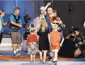  ?? Paul Crock / AFP/Getty Images ?? With his children in tow, countryman Lleyton Hewitt bids the crowd a final farewell as he exits the court after losing to David Ferrer in his final match as a profession­al at the Australian Open in Melbourne on Thursday.