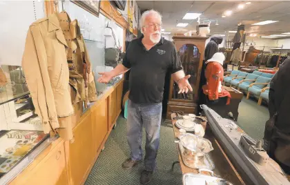  ?? ROB OSTERMAIER/STAFF ?? William Welch of the Phoebus Auction Gallery talks about the collection of historic military gear and equipment that will be up for auction Sunday.
