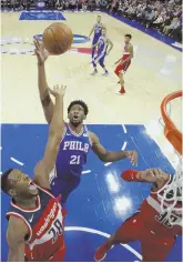  ?? AP PHOTO ?? HIGH TIMES: Philadelph­ia’s Joel Embiid and Washington’s Ian Mahinmi battle for a rebound during the Sixers’ win last night.