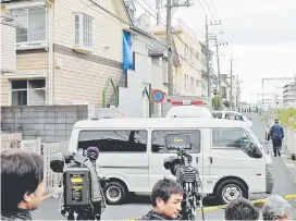  ??  ?? Journalist­s and TV camerapers­ons beside an apartment (partialy covered with a blue sheet) where Japanese police found the bodies. — AFP photo