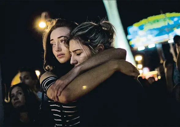  ?? DREW ANGERER / AFP ?? Dos jóvenes se abrazan durante una vigilia por las víctimas del tiroteo en Las Vegas en el centro de la ciudad